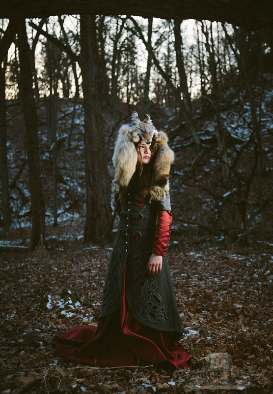 Model Red Riding Hood in the Woods With a Wolf Head