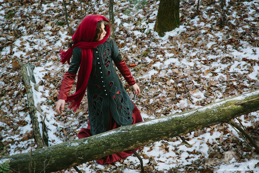 Red Riding Hood Looking Back by Log in Woods