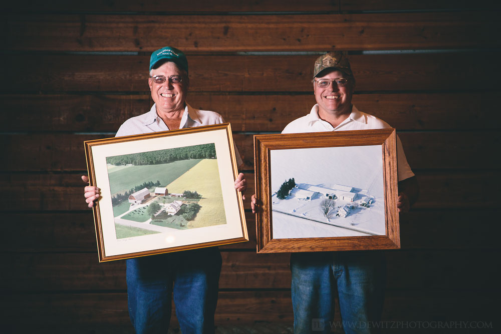 rine_farms_father_and_son_holding_aerial_photos_of_homestead