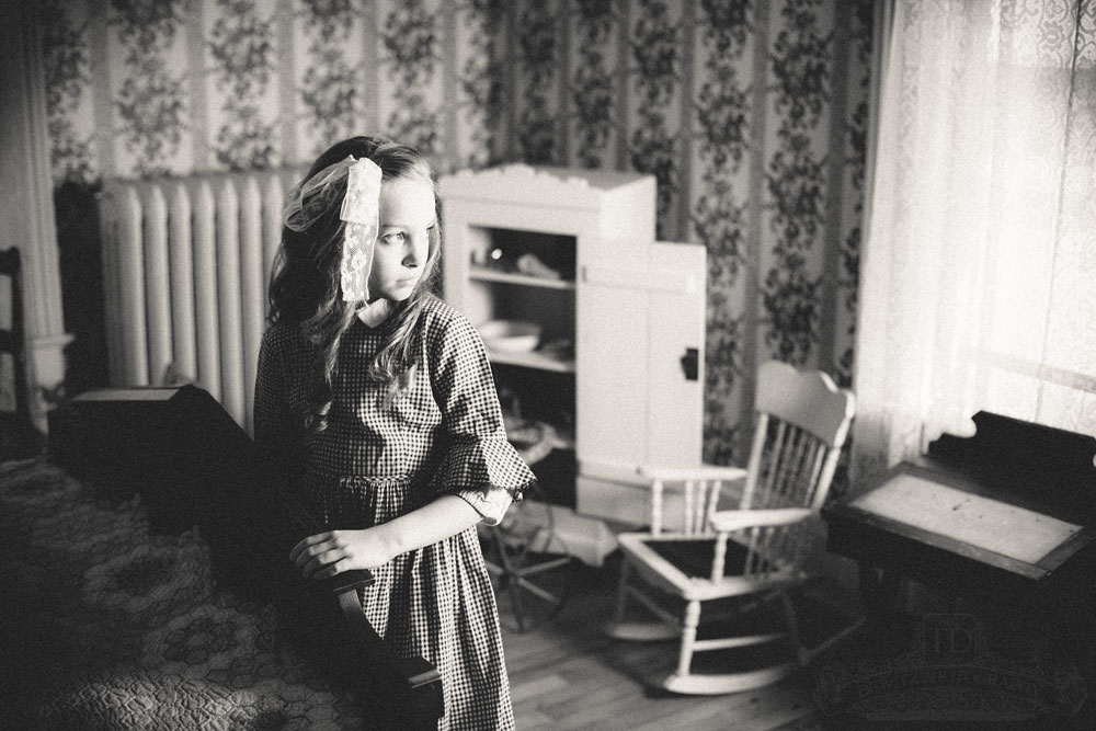 Teslyn at foot of bed in eerie early 1900s childs room
