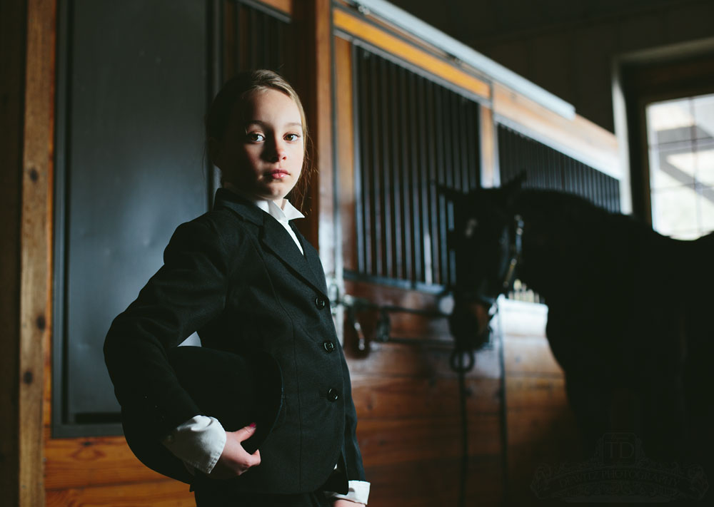 Teslyn in horse stable holding riding helmet