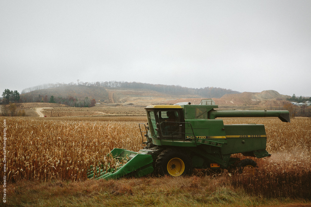 John Deere Combine Cuts Corn as Frac Sand is Mined From the Distant Hill - Sand Creek, WI