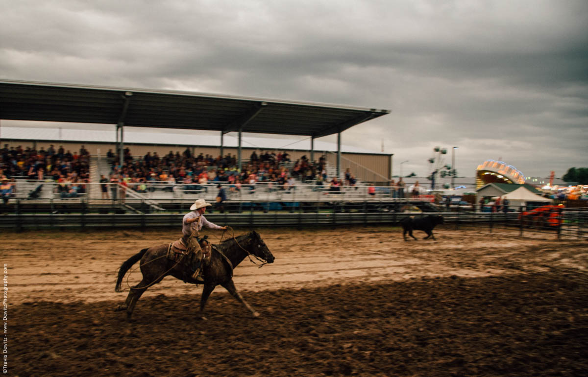 cowboy-roper-runs-horse-lassos-bull-muddy-arena-jackson-county-fair-4937