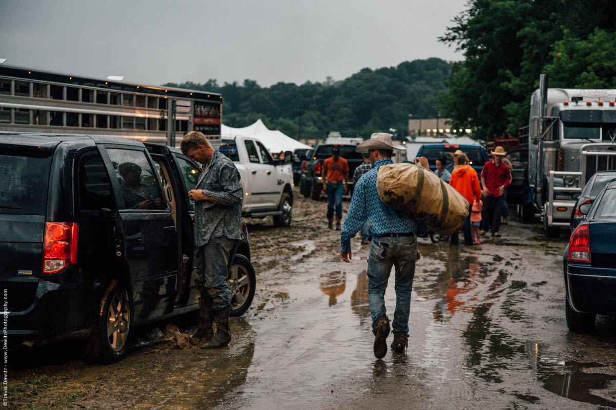 cowboys-carry-bags-getting-ready-for-rodeo-event-in-the-rain-4498